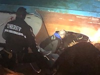 Firefighters used a reciprocating saw to hack into the overturned hull of the Pacific Miner. North Bay Fire District photo.